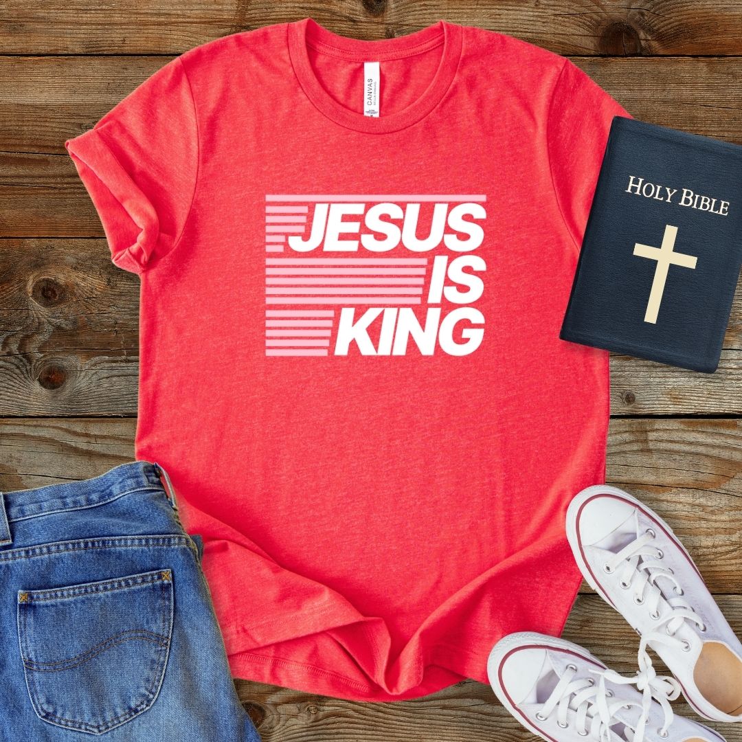 a t - shirt that says jesus is king next to a bible