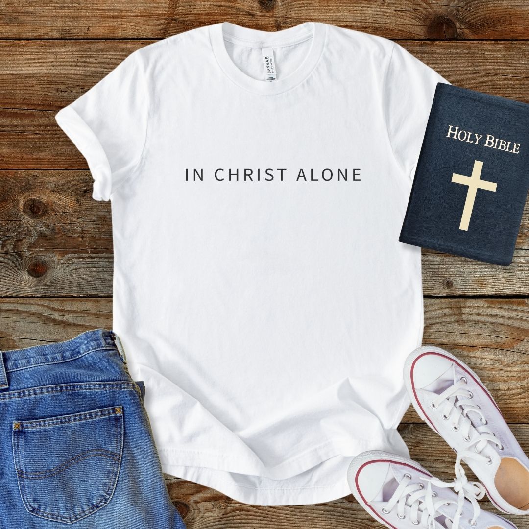 a t - shirt with the words in christ alone on it