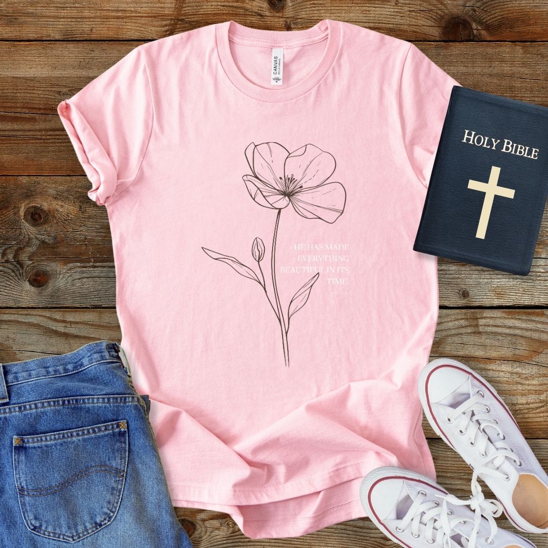 a pink t - shirt with a picture of a flower on it