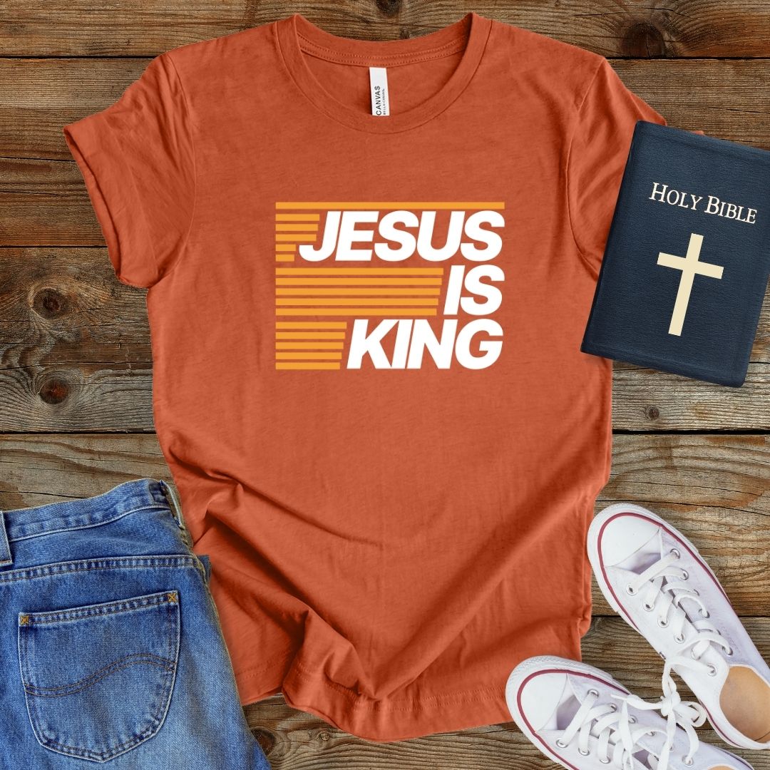 a t - shirt that says jesus is king next to a bible