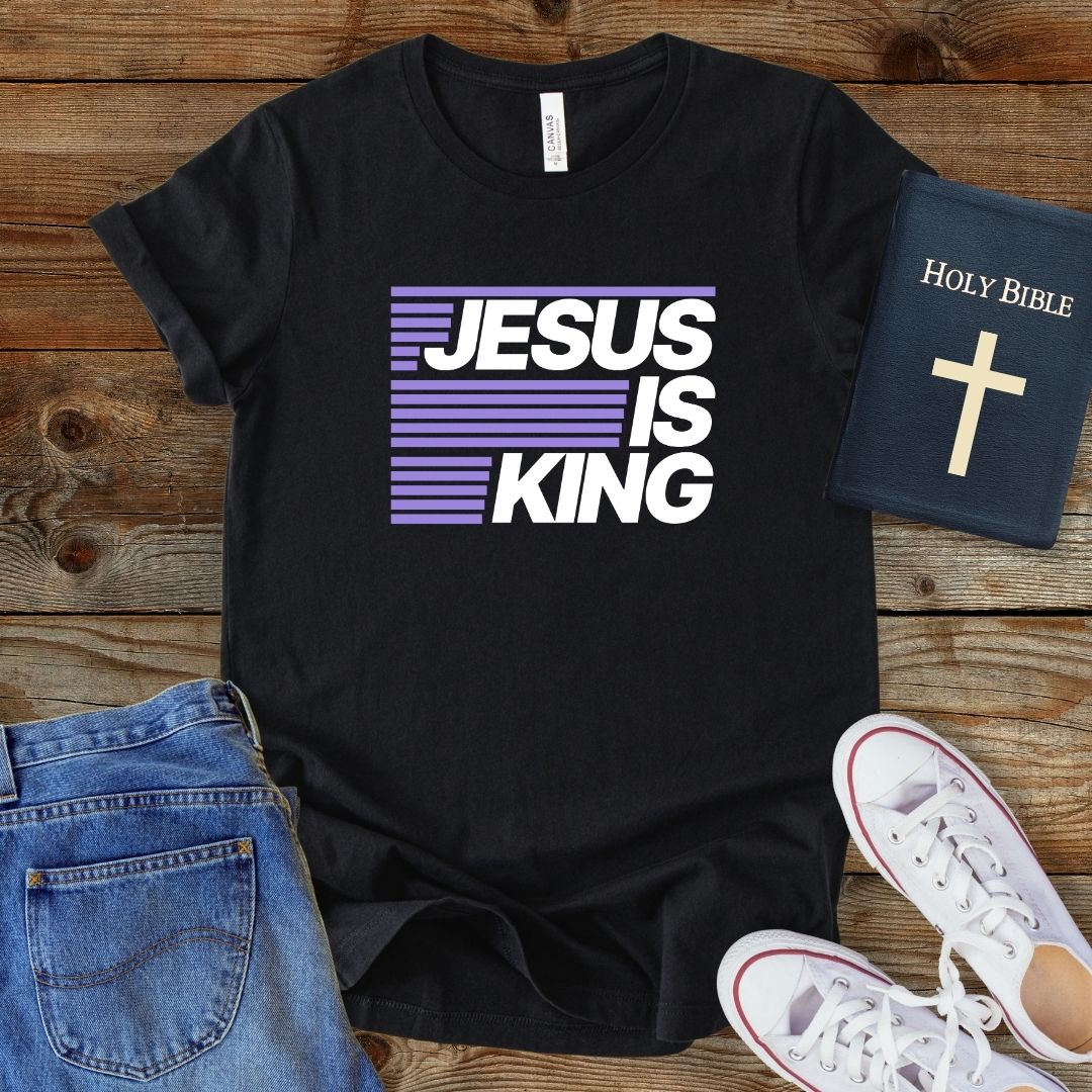 a t - shirt that says jesus is king next to a pair of jeans and