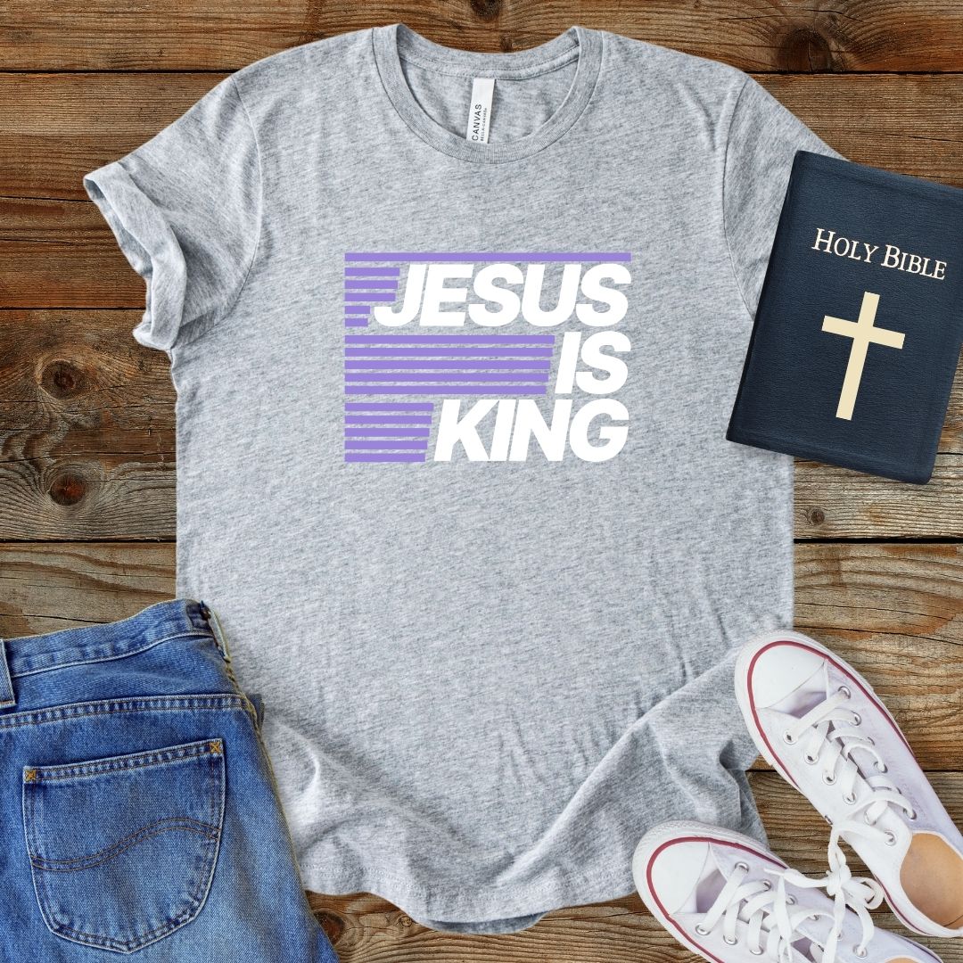 a t - shirt that says jesus is king next to a bible