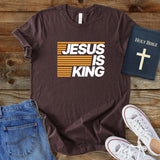 a t - shirt that says jesus is king next to a pair of jeans and