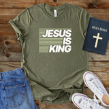 a t - shirt that says jesus is king next to a pair of jeans and