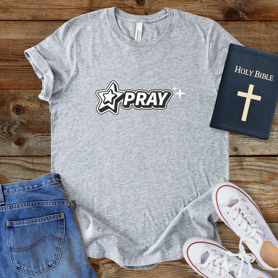 a t - shirt that says pray with a bible next to it