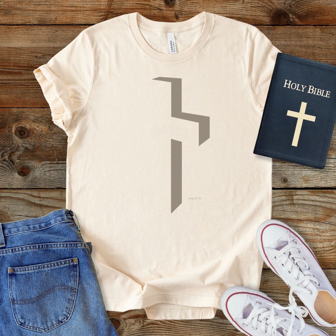 a t - shirt with a cross and a bible next to it