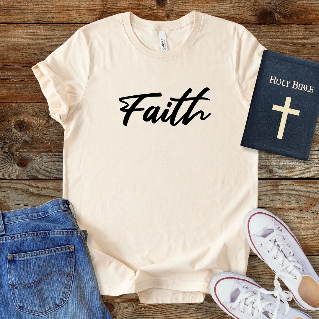 a t - shirt with the word faith on it next to a pair of jeans